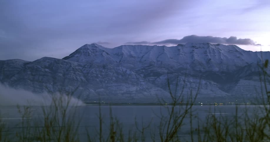 Small town on the coast of a lake near the mountains at sunset