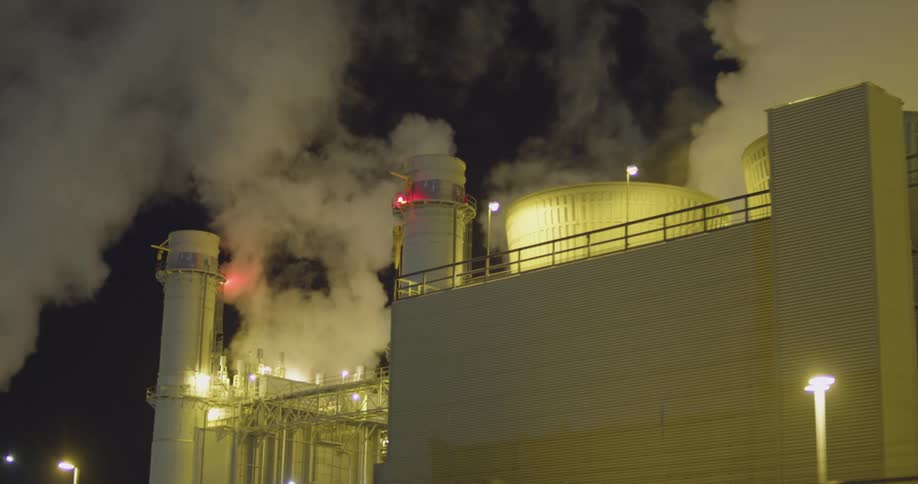 Smoke rising from a Industrial buildings outdoors at night