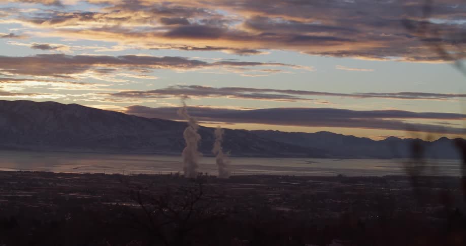 Mountains under a cloudy sky and steam coming from a power plant