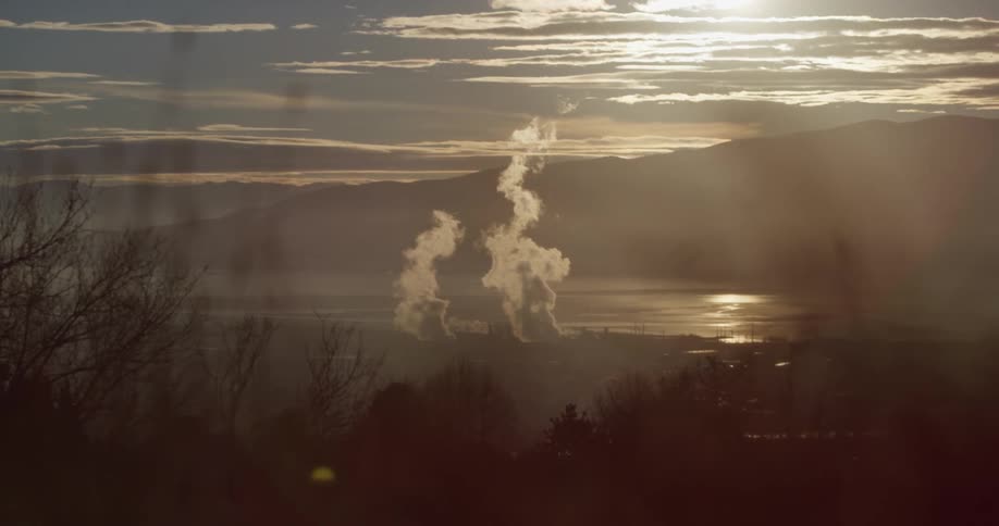 A landscape view of smoke rising in front of the shoreline