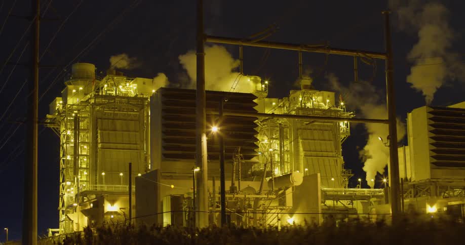 A view of a power plant with smoke coming off of it