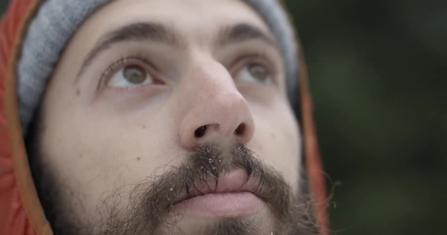 Close-up of a bearded man looking around on a chilly day