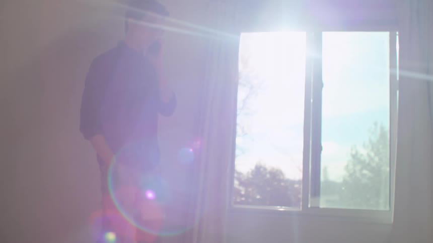 A man talking on a phone while walking in a room