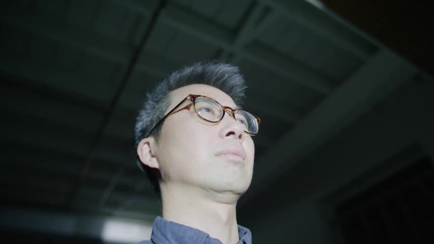A man with glasses in a room with flashing lights