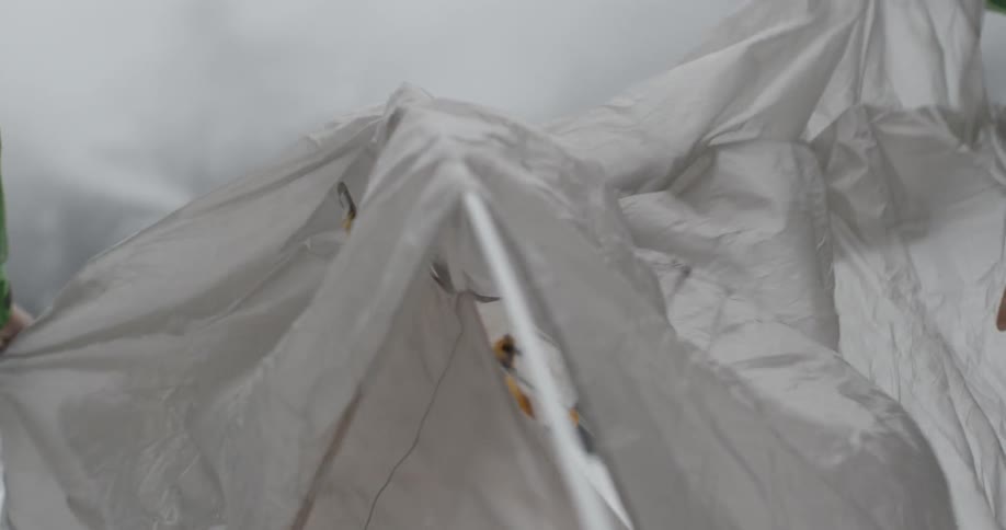 A tent is setup outside in the snowy mountains