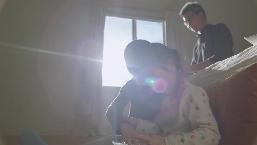 A family sit together in the bedroom