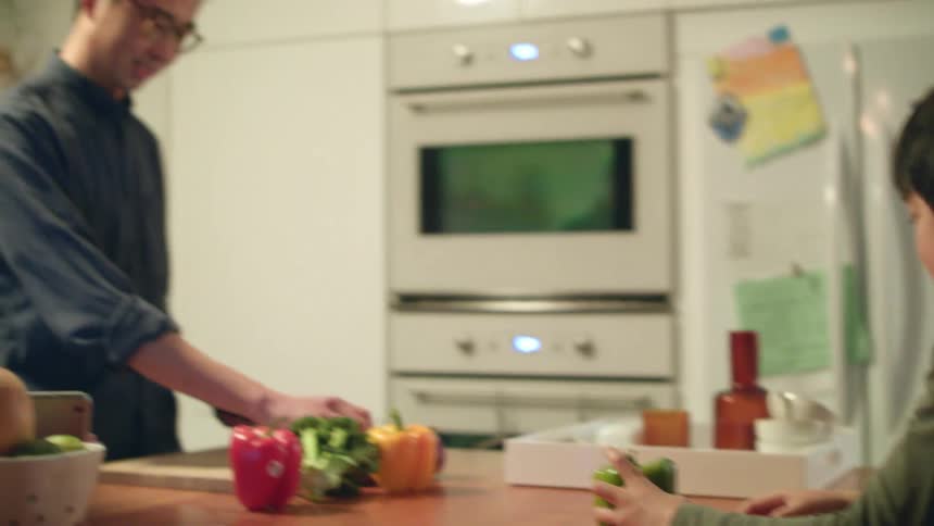 Parents cooking food in the kitchen at home with their children