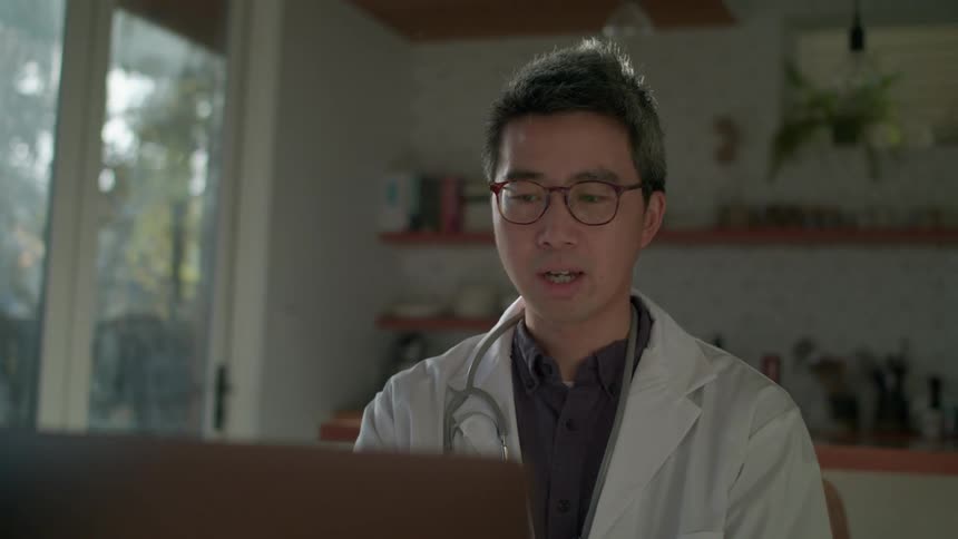 A doctor sitting at a laptop