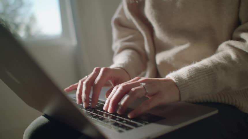 A woman typing on a laptop