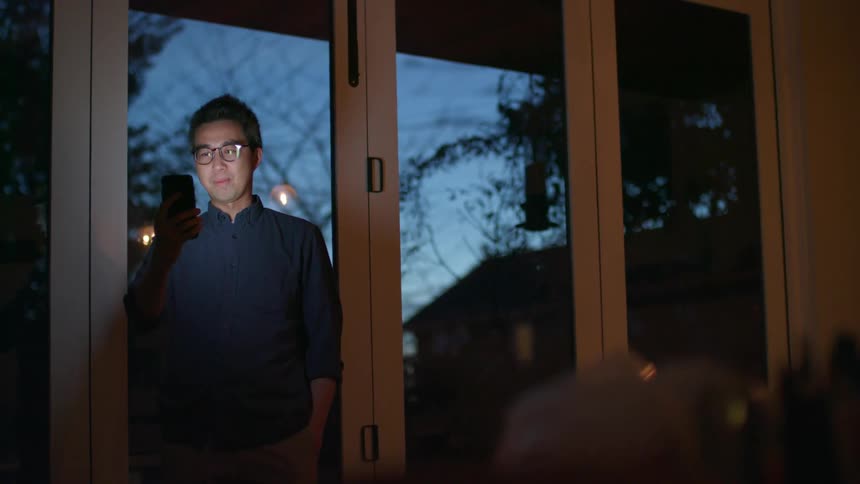 Young man talking on a video call on his smartphone at home in the evening