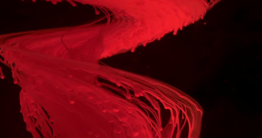 The red ink swirls in the black water
