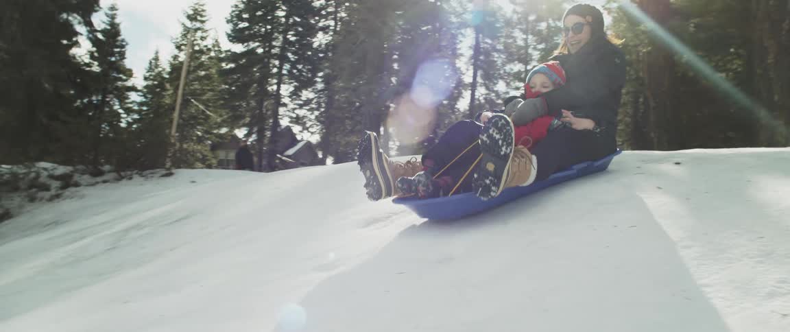 A woman and child sledding