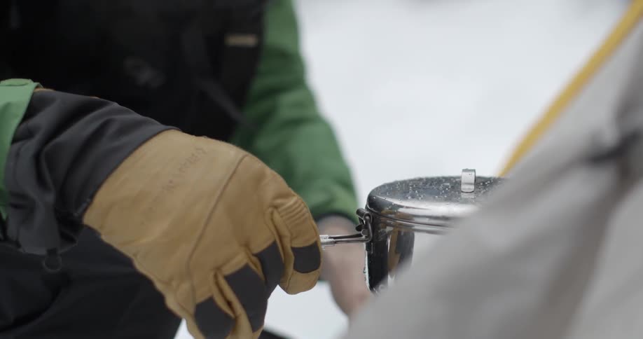 A person puts a pot down by a tent