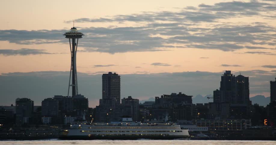 A huge boat is sailing near a city at dawn
