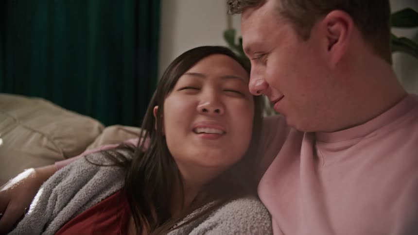 A man and woman sitting on a couch together