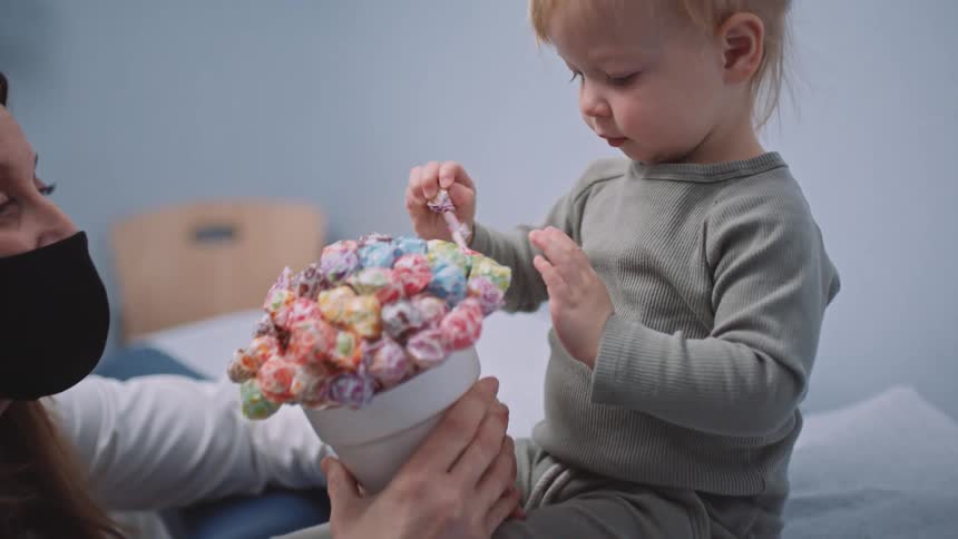 A doctor gives a lollipop to a child