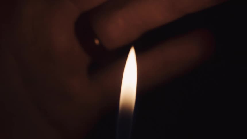 A person lights up their hand in the dark