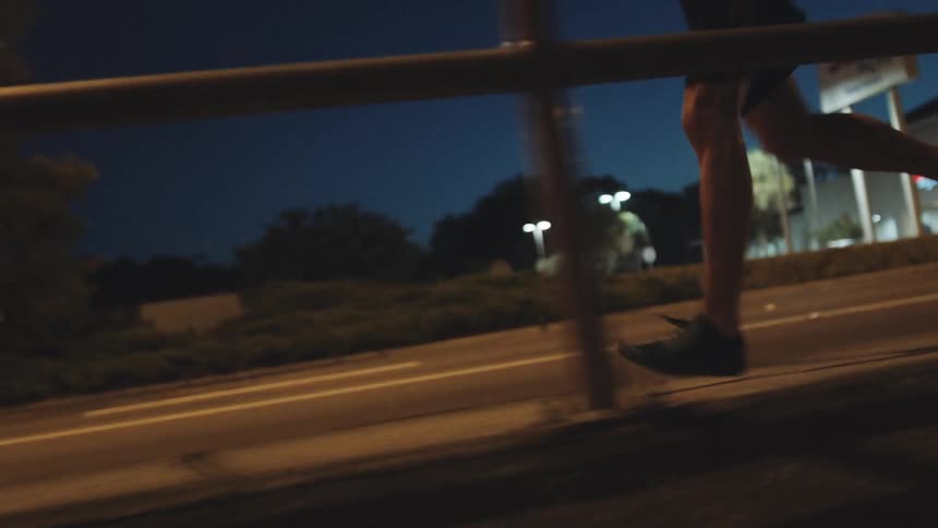 A man is jogging outdoors at night