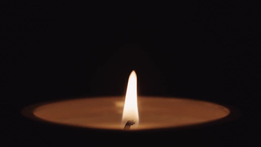 A glowing candle flame is blown out