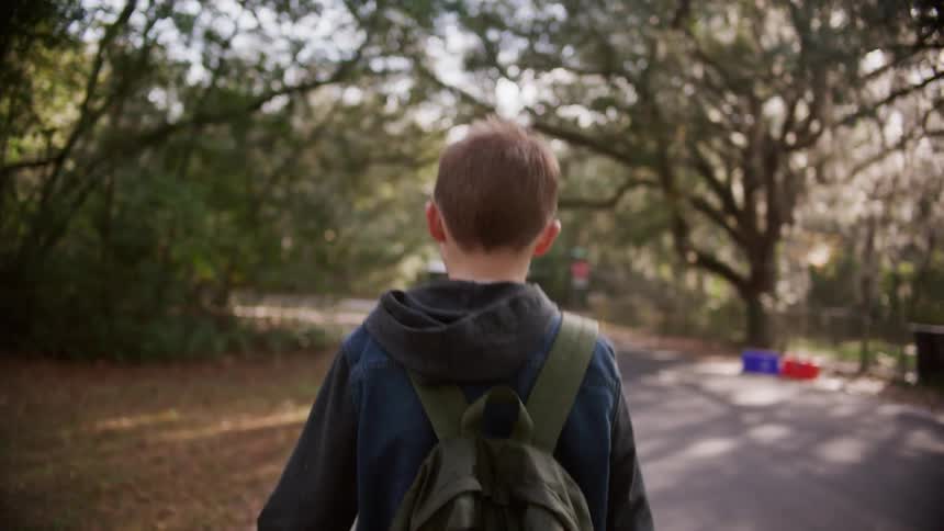 A young boy walks down a neighborhood street