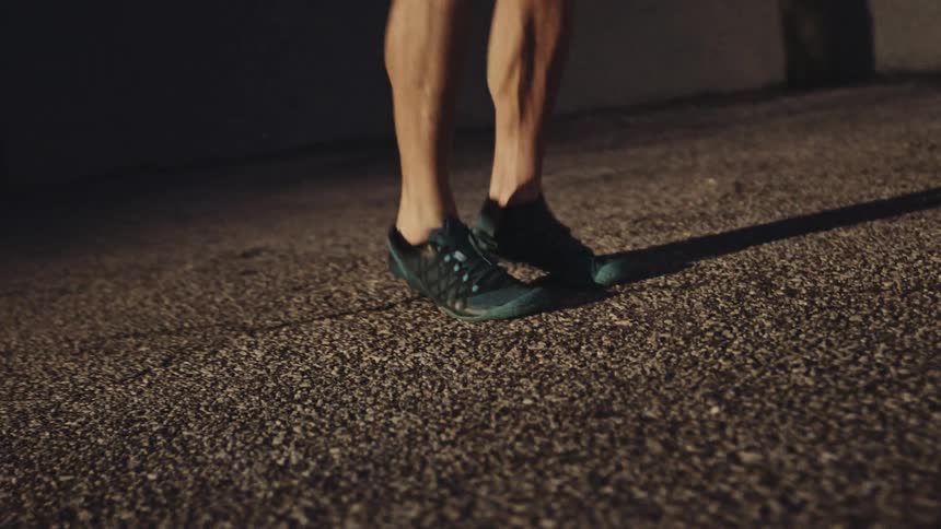 A man is jump roping outdoors while wearing shorts