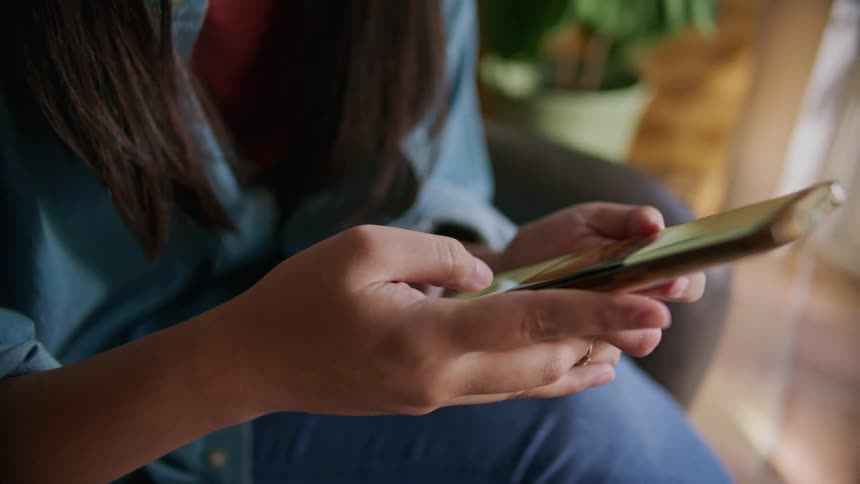 A woman scrolling on her phone while sitting down