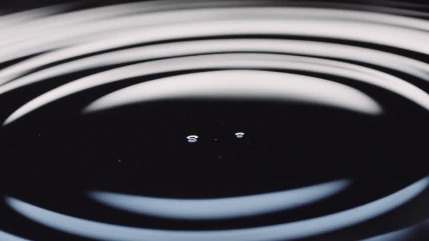 A drop of water falling into a pool of water