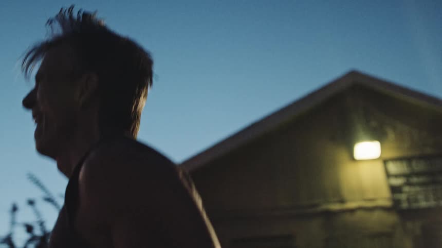 A man jumps rope while working out outside his home at night