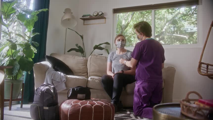 A nurse checking out a patient at home