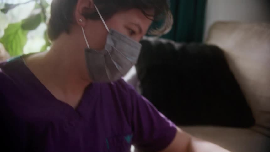 A nurse takes a patients heart rate in her home