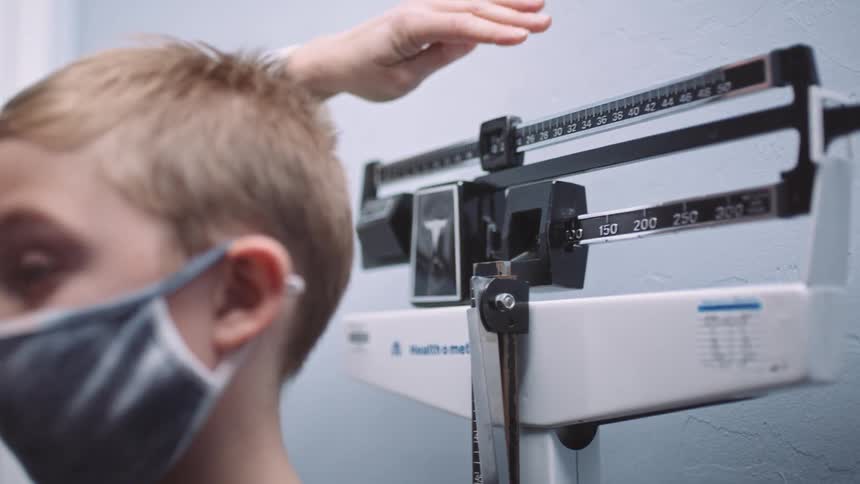 A child being weighed on a scale in a doctors office