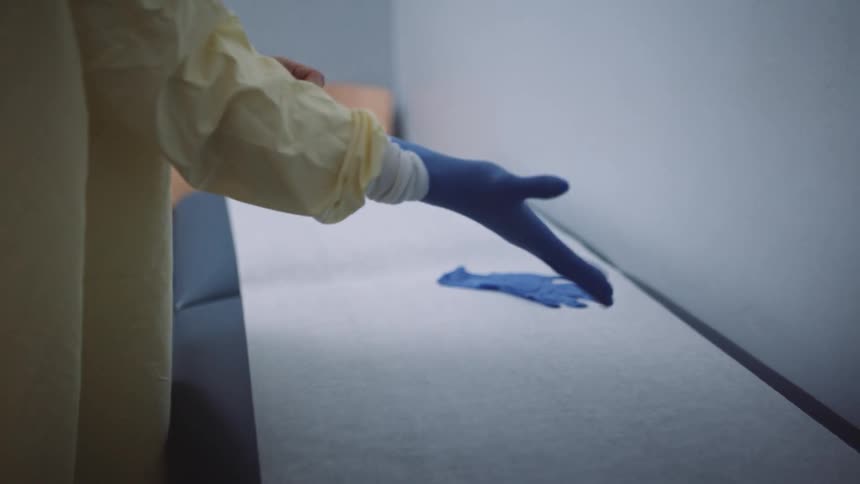 A doctor putting on gloves in a medical office