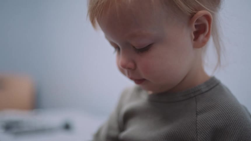 A doctor looks at a device on a childs finger to measure their oxygen saturation levels