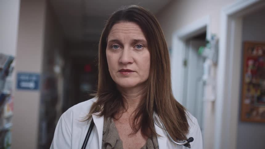 A doctor with a stethoscope and a lab coat standing in a clinic
