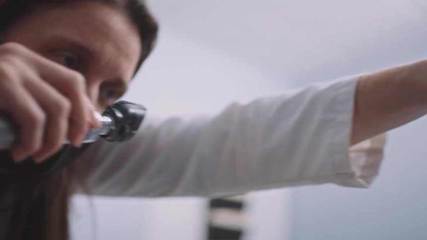 An eye doctor examines a teenagers eyes