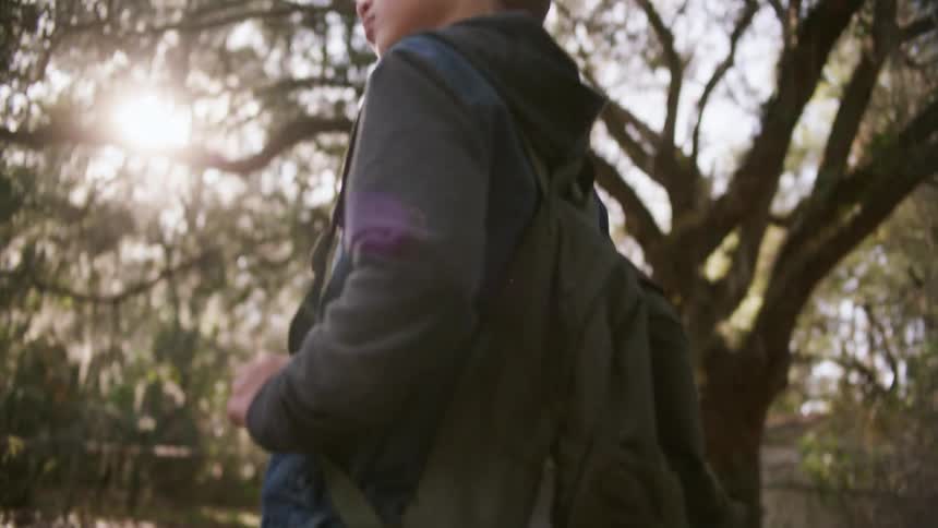 A boy is walking home from school in town