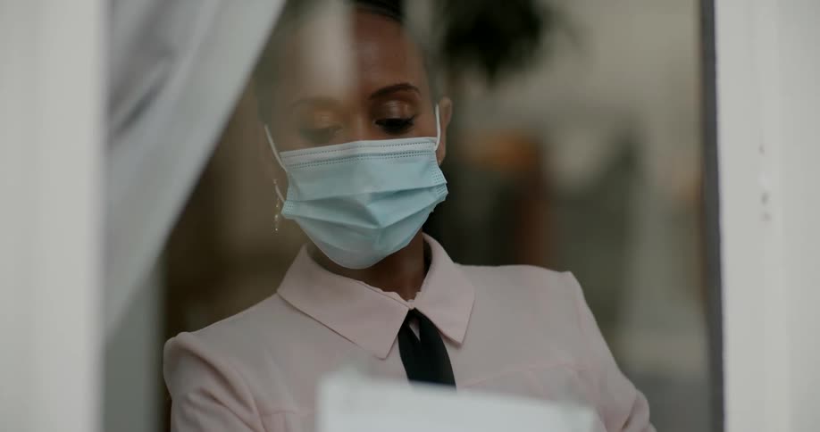 A business owner places a sign on the door stating that face masks are required