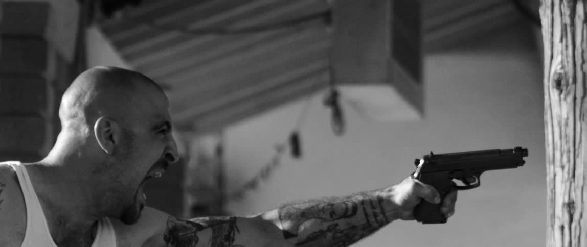 A man hollering as he points a gun
