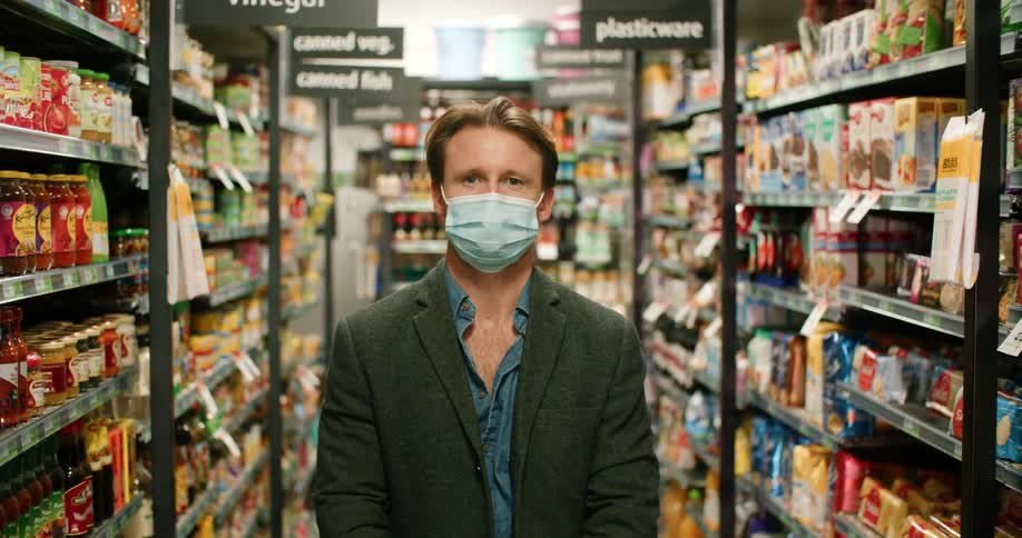 A man standing in an aisle of a grocery store