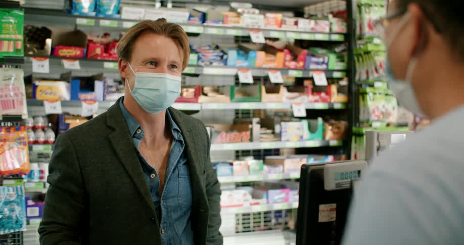 A customer chats with the cashier while checking out at a convenience store