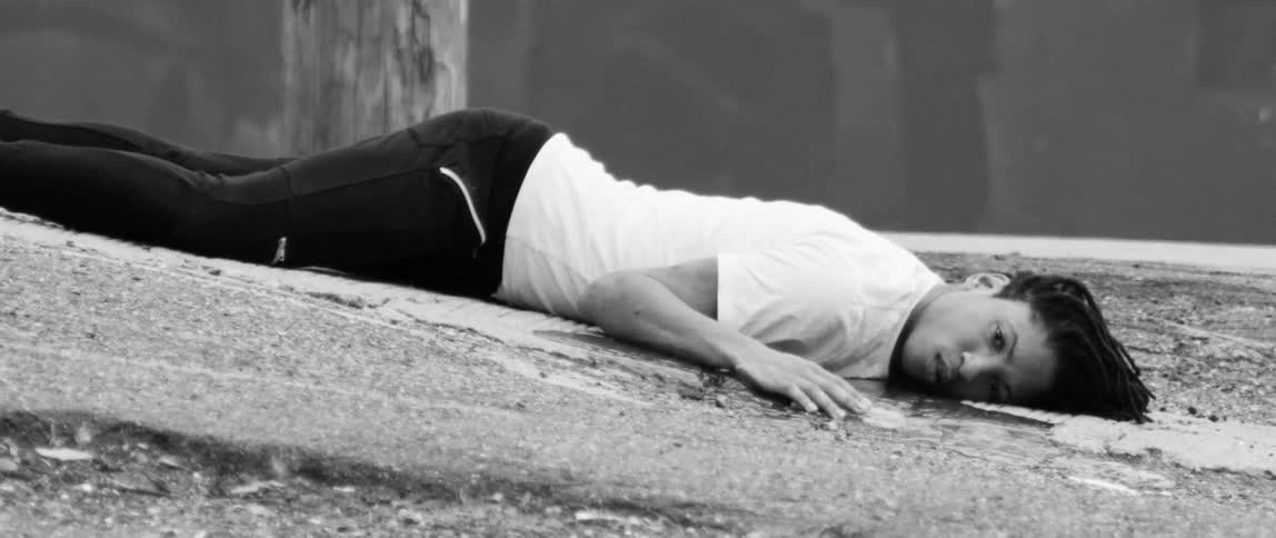 A man is lying face down on gravel