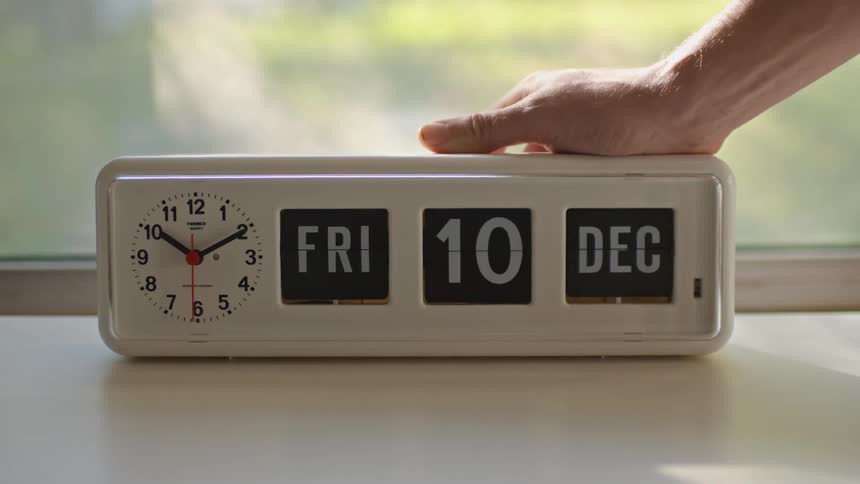 Someone changing the date on an old clock radio