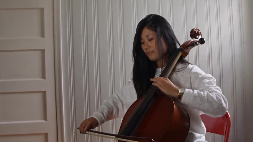 An asian woman playing the cello