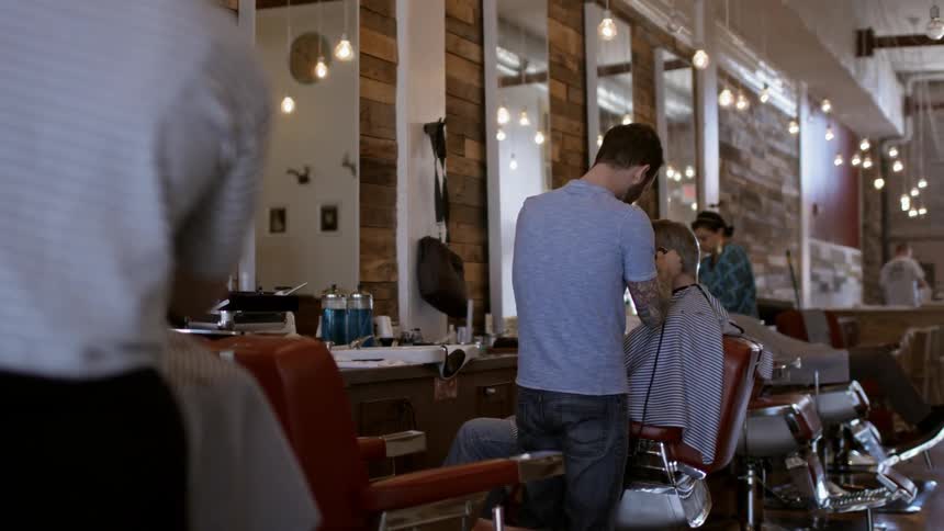 Man receives a haircut in a salon