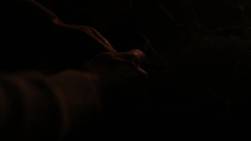 A person is trying to light tinder in a dark area