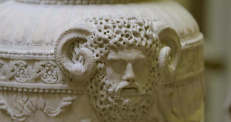 An art piece in a museum features a sculpture with a horned man