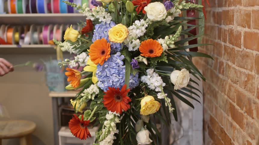 A large arrangement of flowers is being set up