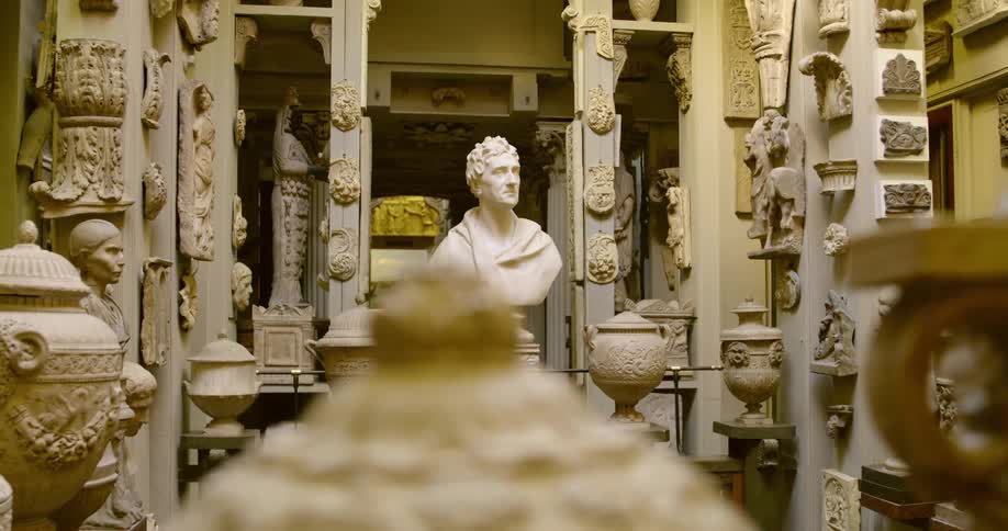 An ornate sculptural art display including busts columns and urns