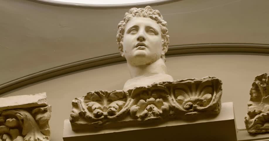 Masculine marble bust perched on a a wall inside a building