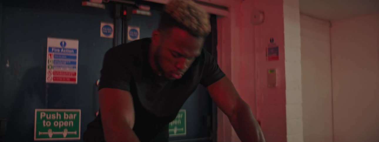 A man exhaling while working out on a stationary bike in a gym